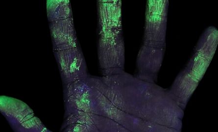 Black light on a hand covered with germs