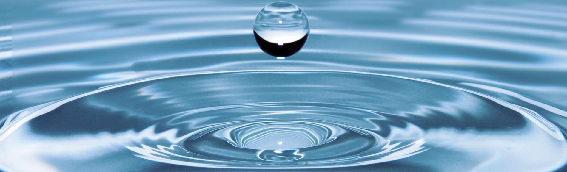 Drop of water splashing in a large pool of water